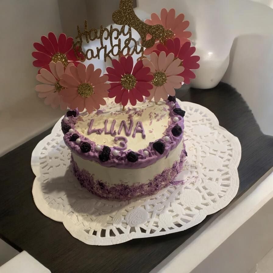 A purple birthday cake decorated for Luna